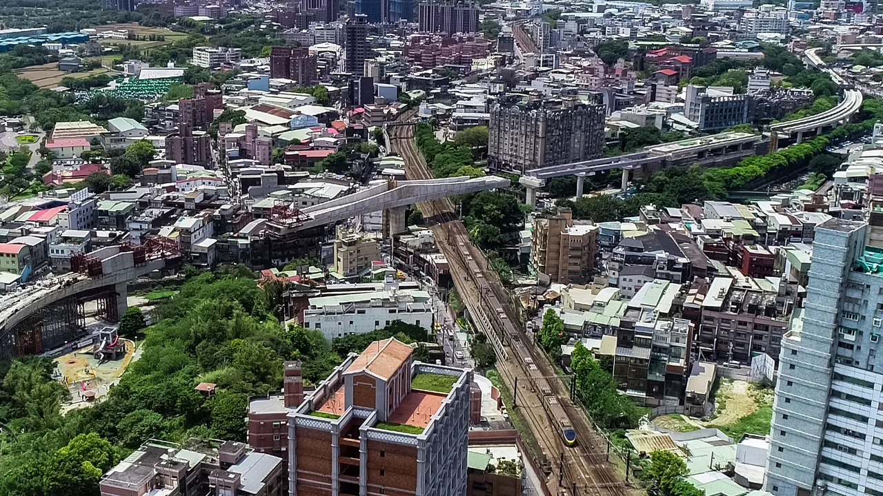 建設中的三鶯線高架軌道與一旁的臺鐵 EMU800 列車